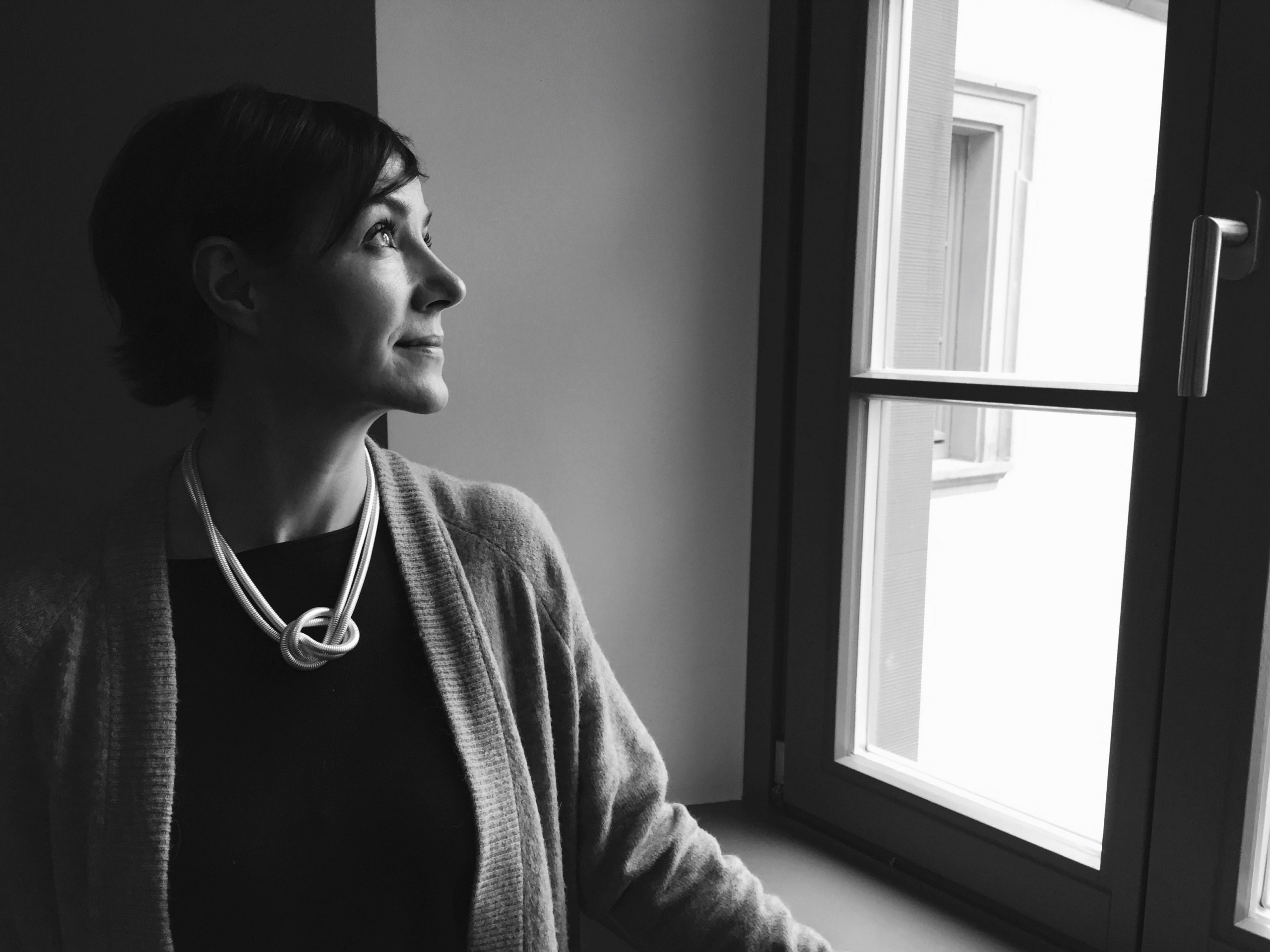 Frau am Fenster, über Vorsätze nachdenkend.